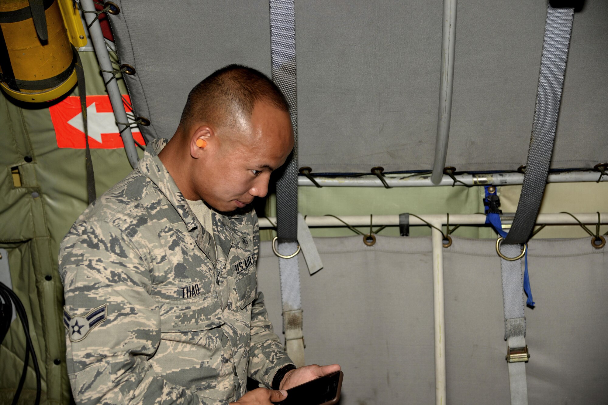 Airman 1st Class Seng Thao, a health services management journeyman assigned to the 6th Medical Support Squadron prepares to photograph his experience in the boom pod. Airmen were given the opportunity to photograph in the boom pod during the refueling of F-22 Raptors. (U.S. Air Force photo by Airman 1st Class Rito Smith)