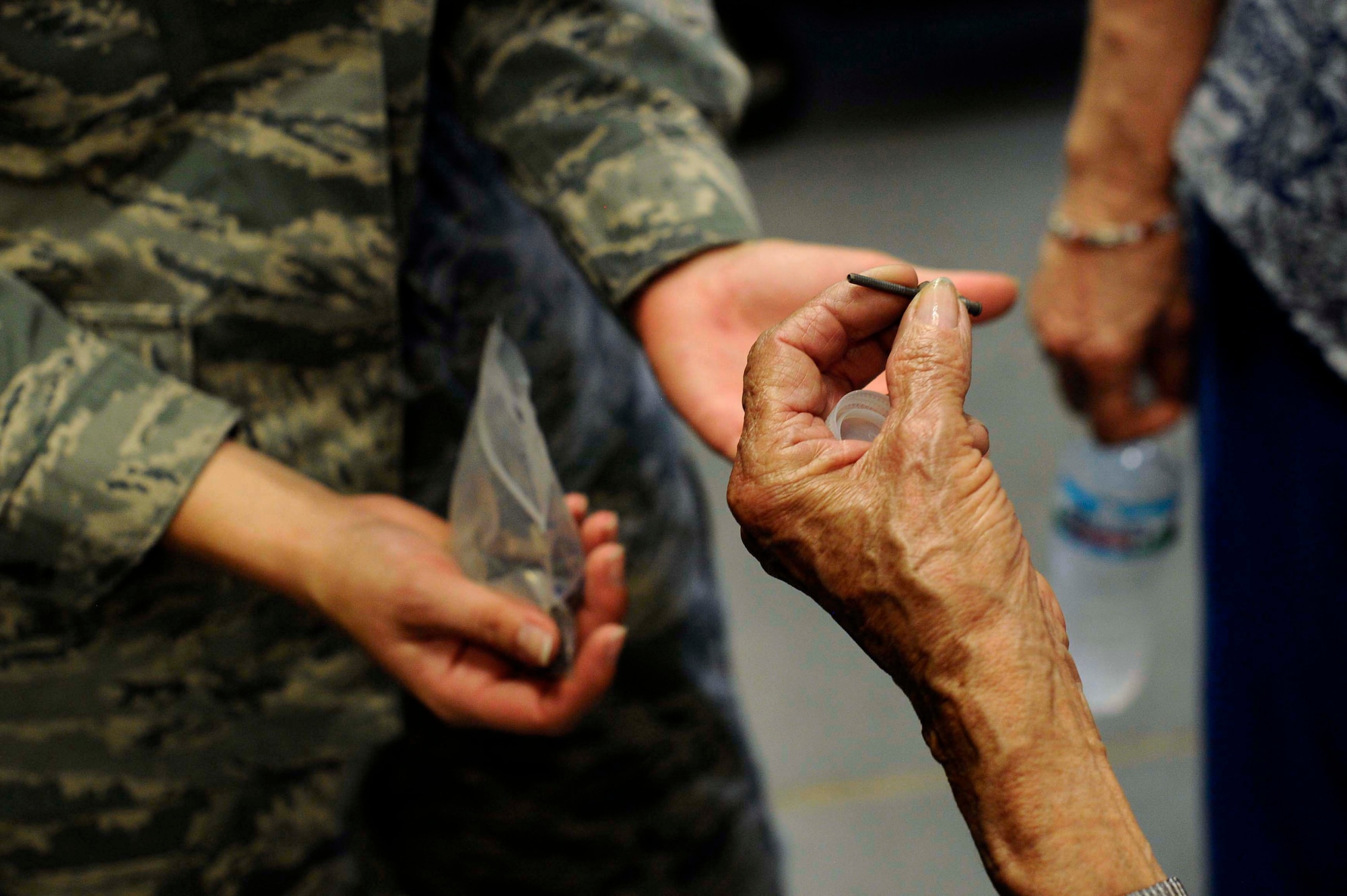 Connie Palacioz, a riveter during World War II, examines a rivet, July 20, 2016, at McConnell Air Force Base, Kan. Palacoiz recently visited the base sheet metal shop where she learned about the mission of the shop and about the job of aircraft structural maintenance Airmen. (U.S. Air Force photo/Airman 1st Class Jenna K. Caldwell)
