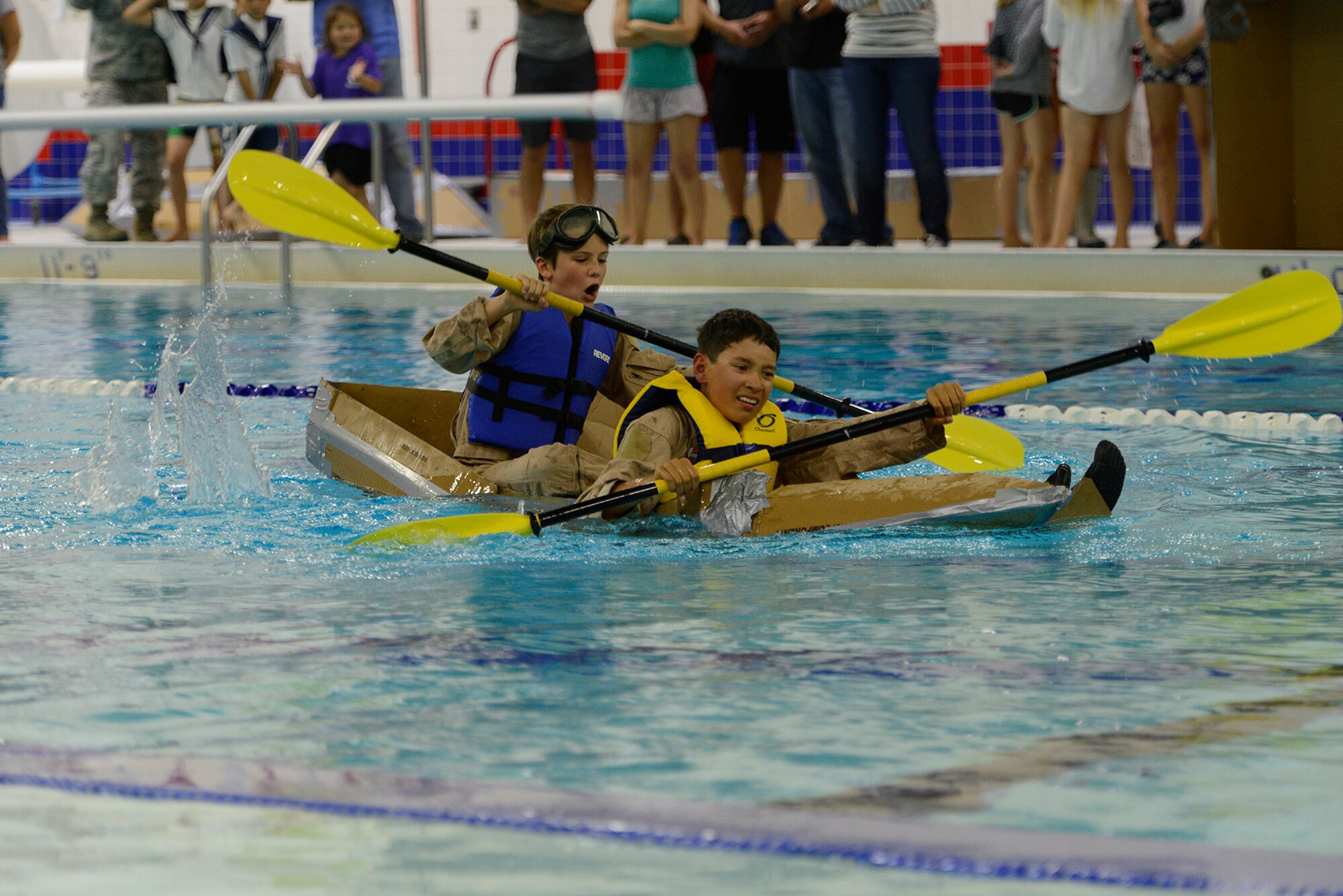Luke Matthews, 12, and jack Abba, 11, race their cardboard vessel at the Build-A-Boat competition at Buckner Physical Fitness Center at Joint Base Elmendorf-Richardson, Alaska, July 23, 2016.  Prizes for fastest time, best capsizing, team chant, and costume were given following the boat race. (U.S. Air Force photo by Airman 1st Class Javier Alvarez)
