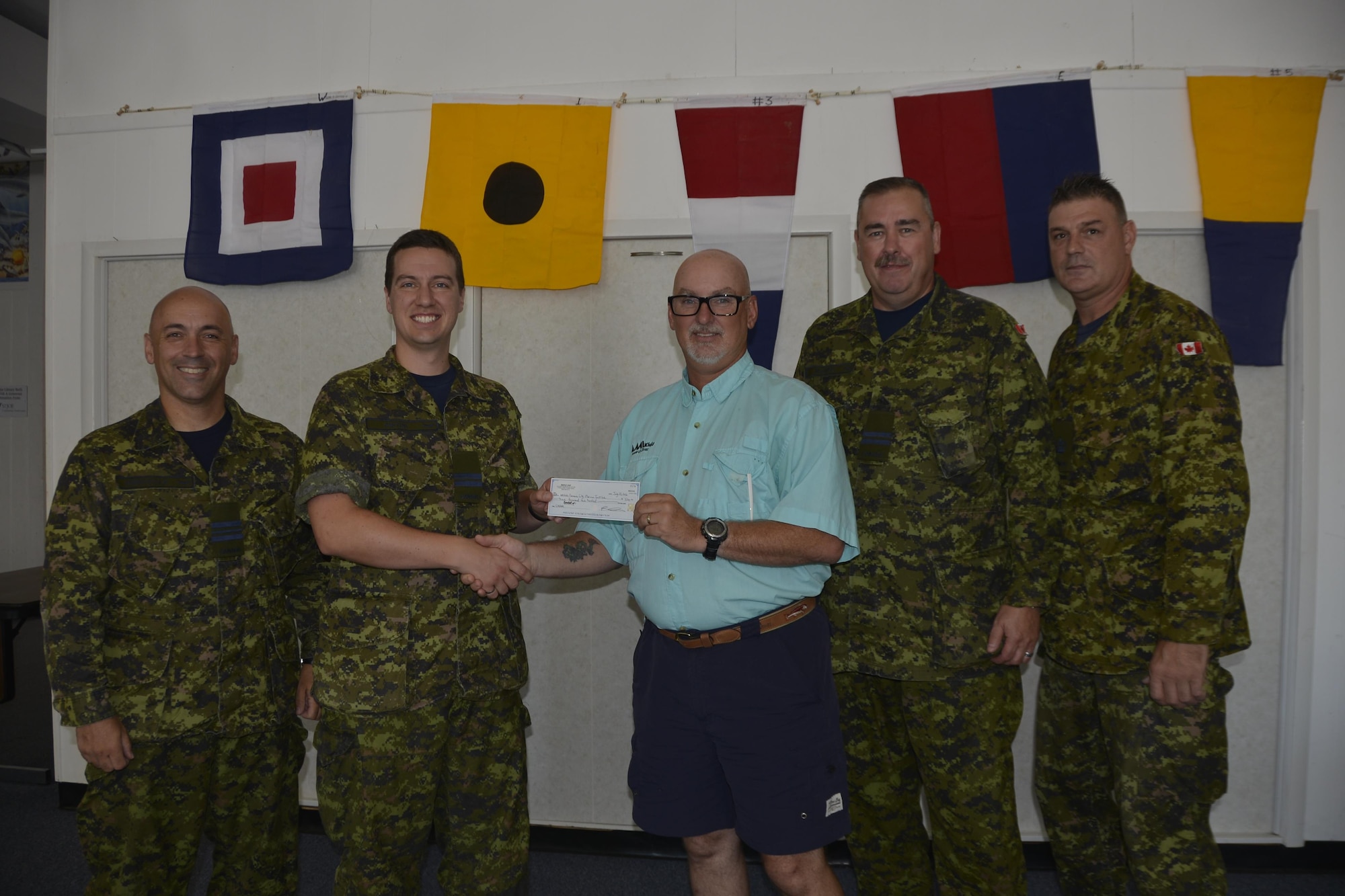 Royal Canadian Air Forces Capt Tim Pistun, 101st Aerospace Communications Squadron, presents the check on behalf of the Canadian Element North American Aerospace Defense Command for $3200 to Ron Boyce, AMIkids Panama City Marine Institute Executive Director July 25 at the PMCI office. Also in attendance were, from left, Maj Dan Ceniccola, 101st ACOMS; Capt Mike MacNeil, 10st ACOMS and WO Darren Guitard, Assessments, Lessons Learned and Exercises Directorate. The funds were raised during the Canadian Element’s annual Canadian American Golf Tournament, an annual activity they hold to benefit a local community charity each year. (U.S. Air Force photo by Mary McHale)