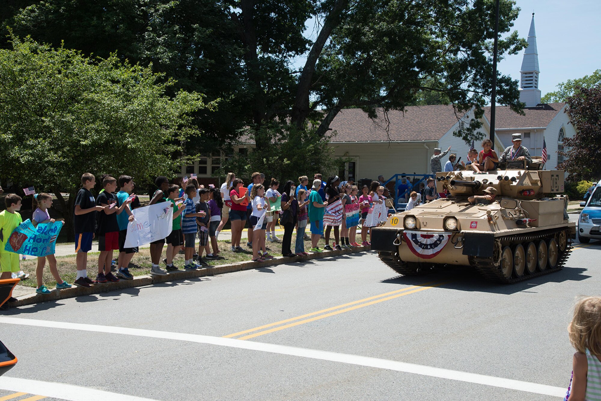 Tech Sgt. Julia Souza, executive assistant for the Hanscom Command Chief Master Sgt. Patricia L. Hickey, participates in a parade with her children during the Hanscom Heroes Homecoming Parade July 21. The annual homecoming event included a formal medallion ceremony at the base conference center followed by a parade through the installation. (U.S Air Force photo by Mark Herlihy)