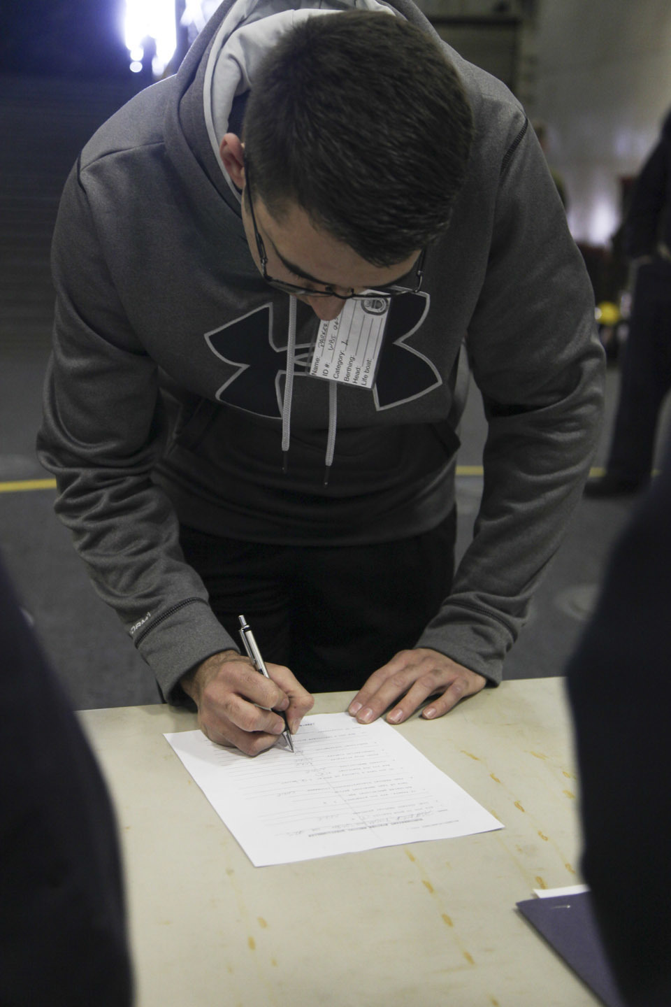 A simulated evacuee completes a medical screening form during an evacuation control center drill aboard the USS Whidbey Island (LSD 41), April 13, 2016. The Sailors conducted the exercise to simulate and validate procedures that would be used during an evacuation. 