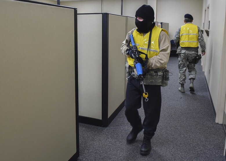 Tech. Sgt. Michael Skarba, 910th Security Forces Squadron training program manager, walks through the base supply building firing blank rounds from an M-4 training rifle here, July 26, 2016. Skarba portrayed the perpetrator in an active shooter exercise here, July 26, 2016. The exercise involved the entire base with all buildings going into lock down and some work centers being evacuated while Wing Inspection Team members evaluated. The scenario was designed to test responses from building managers and occupants and installation security forces. (U.S. Air Force photo/Eric White)