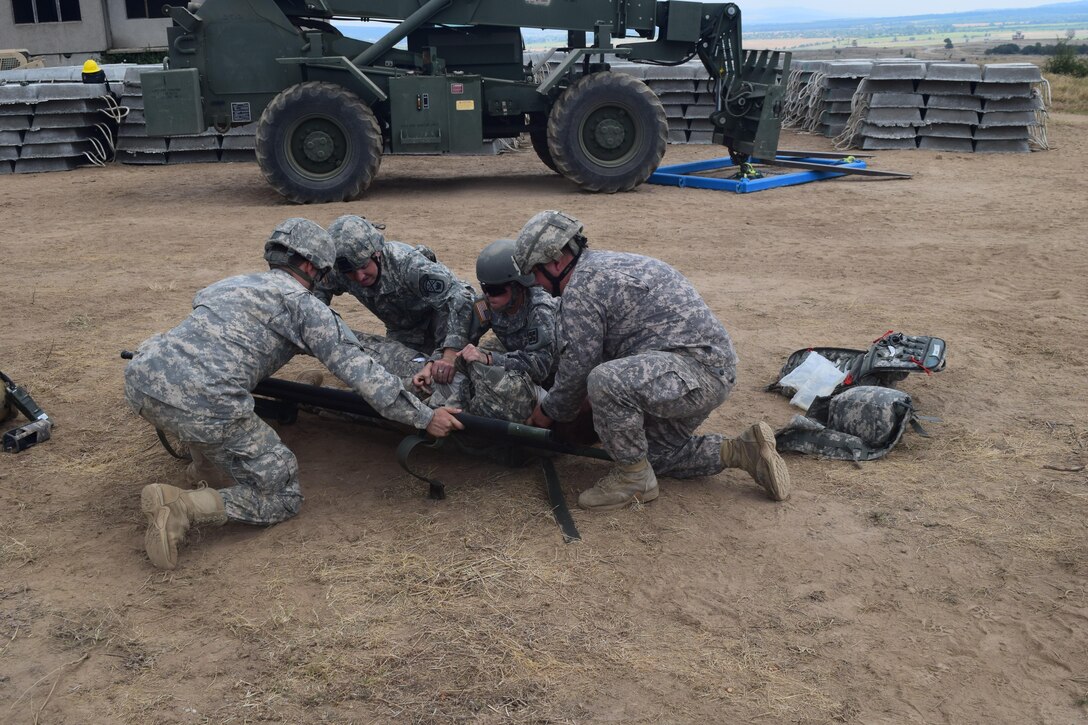 Medical soldiers from the 841st Engineer Battalion and the 268th Military Police Company, 194th Engineer Brigade, Tennessee Army National Guard, prepare to lift a simulated casualty onto a stretcher. These types of injuries require minimal movement of the casualty and enhanced care. The soldiers executed this battle drill in order to ensure familiarization and efficiency in coordinating between units. This training was held at Novo Selo Training Area, Bulgaria as part of Operation Resolute Castle 16, July 23, 2016. (U.S. Army photo by Capt. Jose F. Lopez Jr., 841st Eng. Bn., United States Army Reserve)