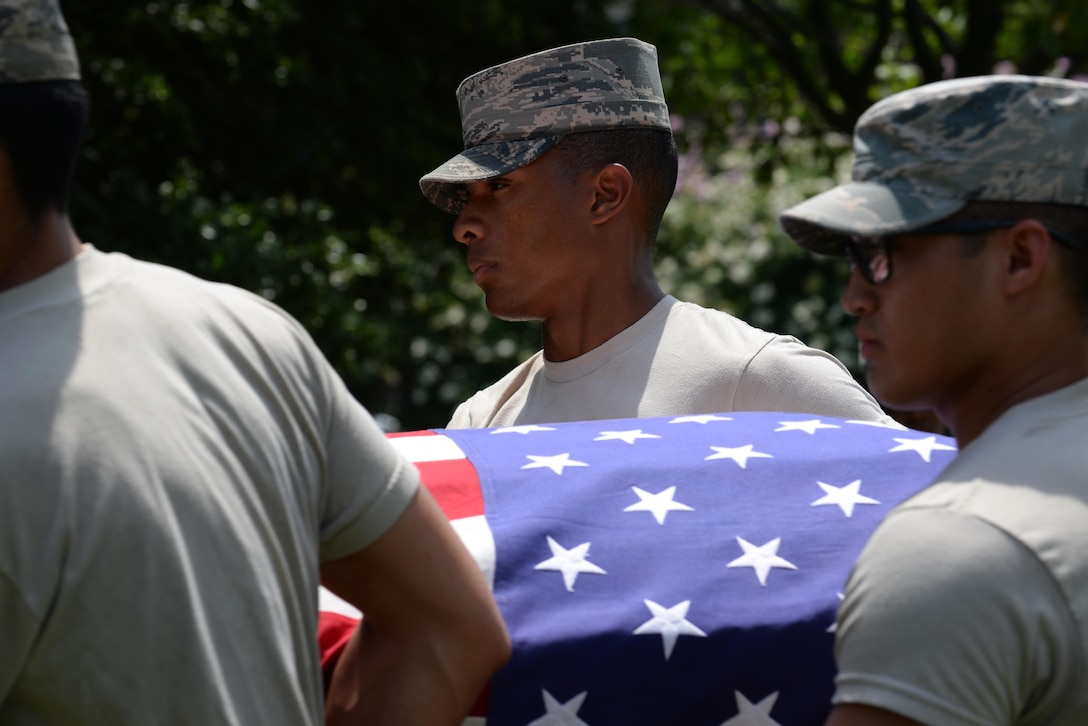 U.S. Air Force Airman 1st Class Anthony Glisson, U.S. Air Force Honor Guard ceremonial guardsman, assists in a demonstration of an active duty funeral at Langley Air Force Base, Va., July 26, 2016. Mobile training teams from the USAFHG travel to installations to teach base honor guard members the proper procedure for a full service funeral. (U.S. Air Force photo by Staff Sgt. Teresa J. Cleveland)