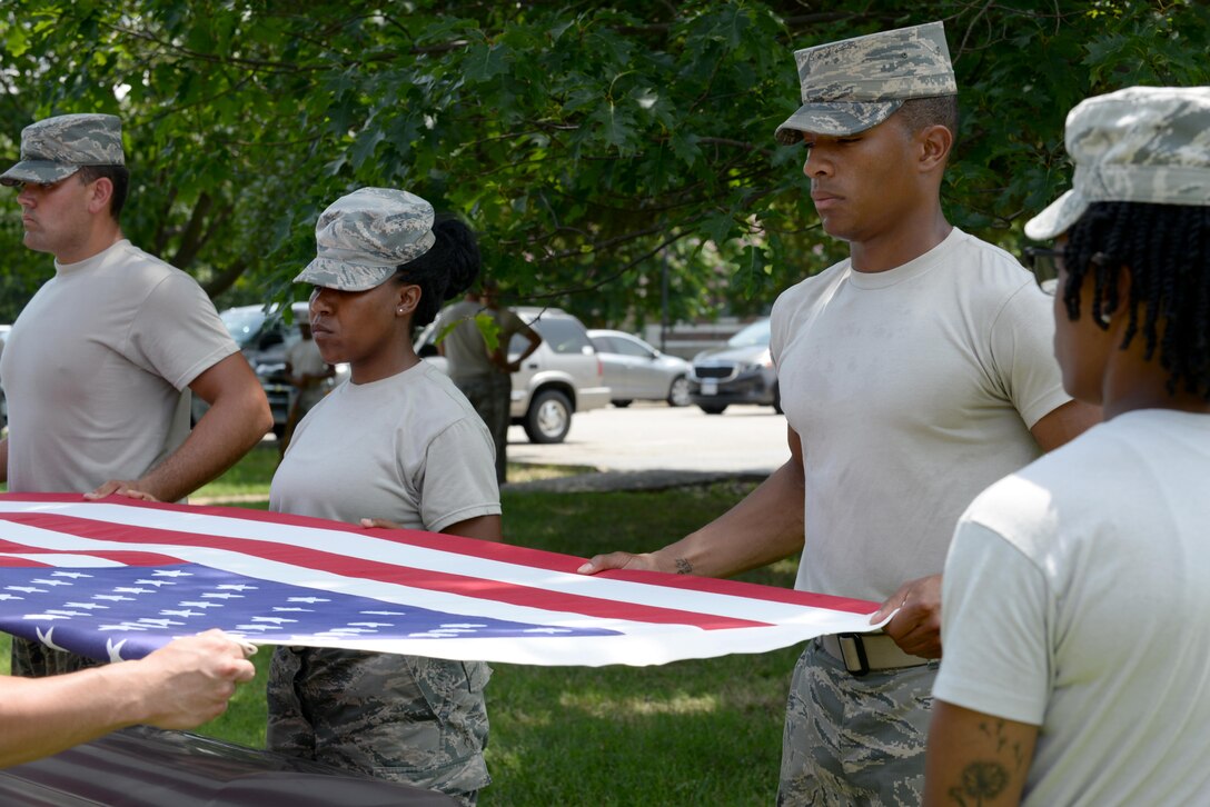 U.S. Air Force Airman 1st Class Anthony Glisson, U.S. Air Force Honor Guard ceremonial guardsman, assists in a demonstration of an active duty funeral at Langley Air Force Base, Va., July 26, 2016. Mobile training teams spend between eight and 10 days at each installation they visit to train base-level ceremonial guardsmen. (U.S. Air Force photo by Staff Sgt. Teresa J. Cleveland)