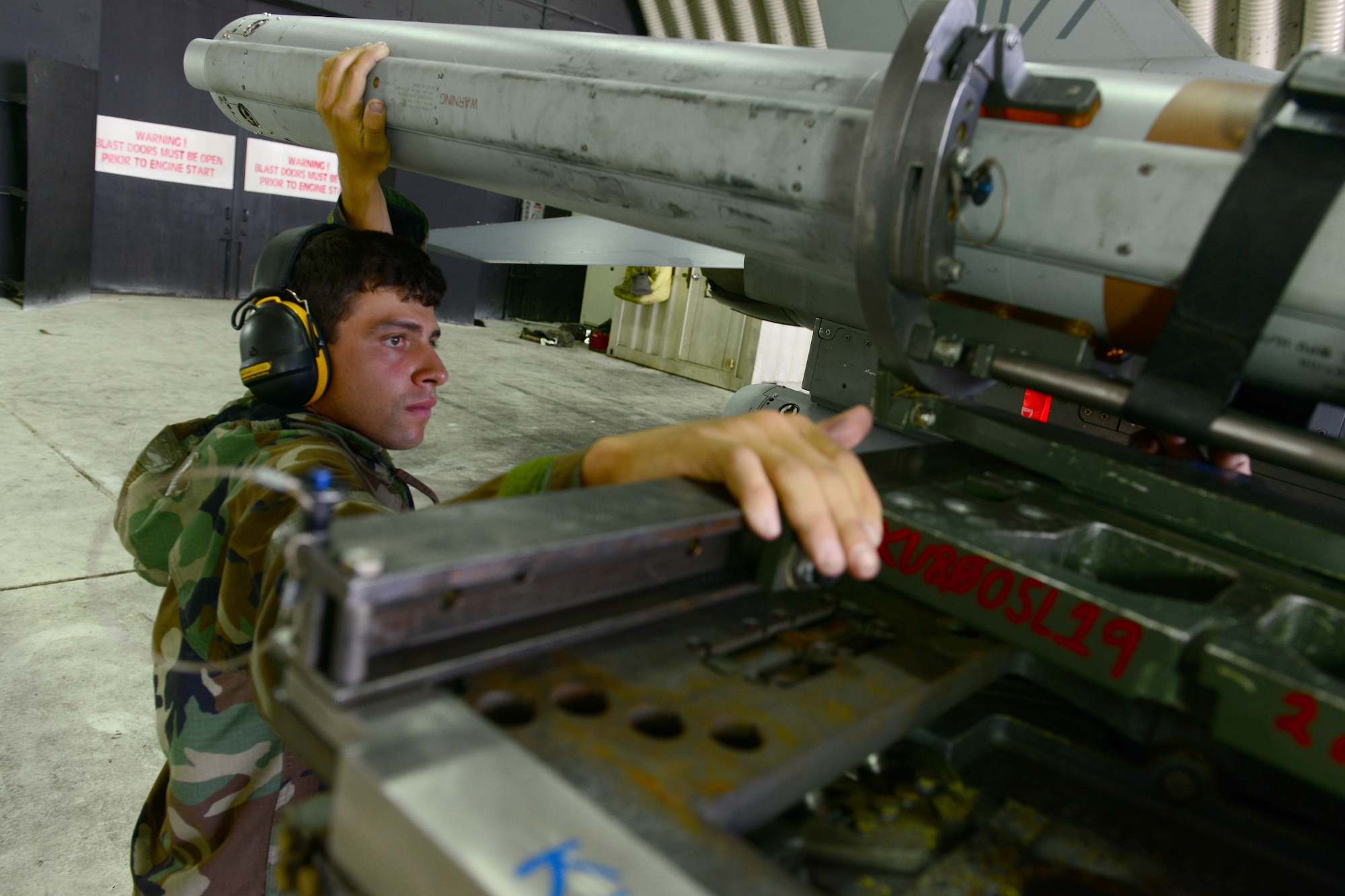 Airman 1st Class Antoni Guarano, 8th Aircraft Maintenance Squadron weapons crew member, aligns a missile to be detached from an F-16 Fighting Falcon during Beverly Pack 16-4 at Kunsan Air Base, Republic of Korea, July 25, 2016. The exercise tested Airmen on their ability to survive and operate while under the stress of simulated wartime activities. (U.S. Air Force photo by Senior Airman Ashley L. Gardner/Released)