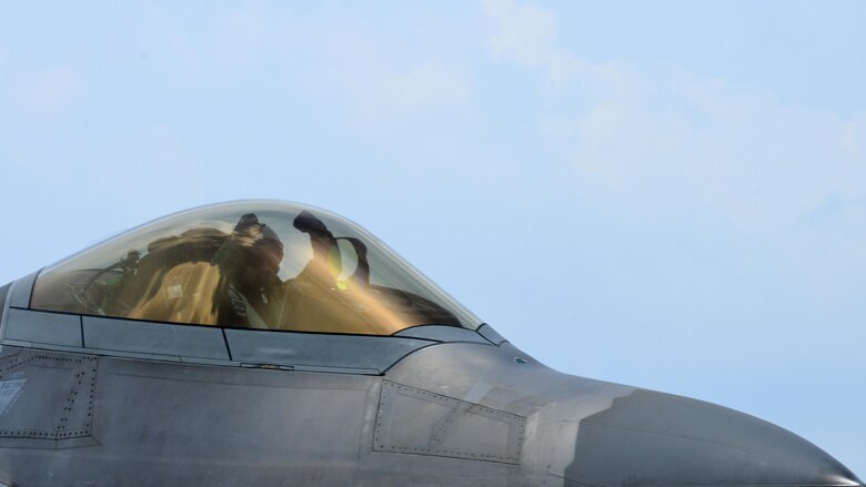 A U.S. Air Force F-22 Raptor pilot from the 1st Fighter Wing taxis on the flight line at Langley Air Force, Va., following a 95th Anniversary Maj. Gen. William “Billy” Mitchell memorial reenactment, July 22, 2016. In honor of Mitchell, pilots from across the Air Force gathered to reenact Mitchell’s airpower trials which demonstrated aviation’s place in the U.S. military on July 21, 1921. (U.S. Air Force photo by Staff Sgt. R. Alex Durbin)