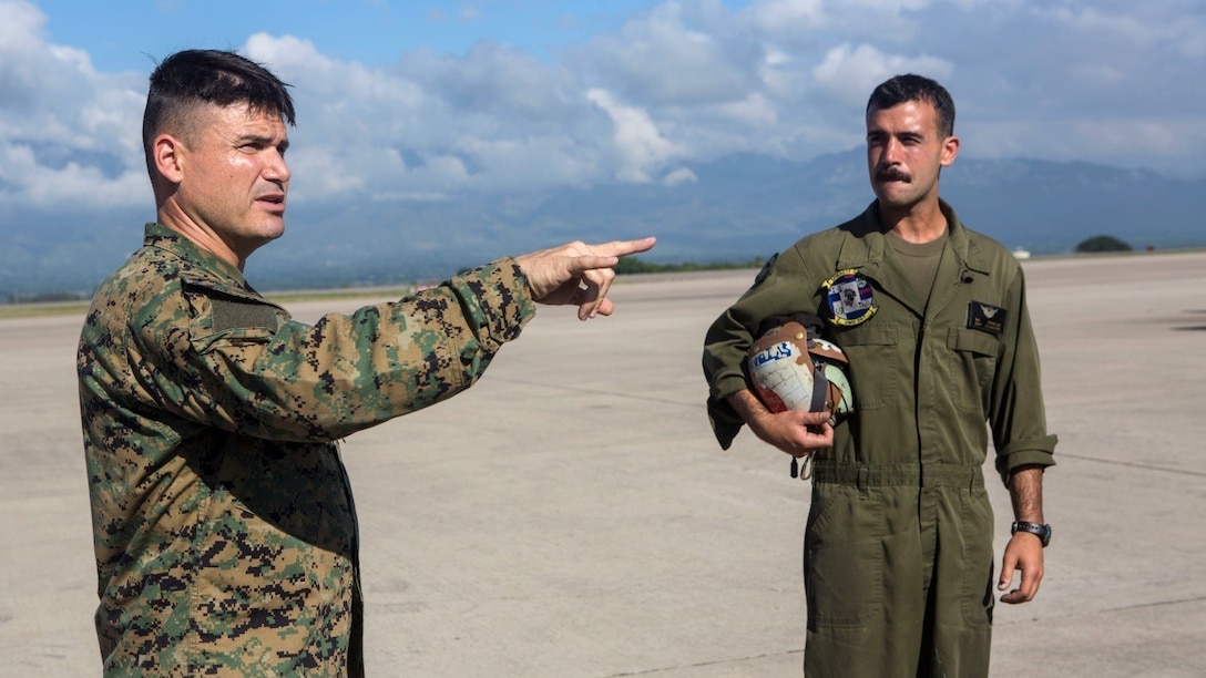 Maj. Clinton Cummings (left), the Humanitarian Assistance Survey Team officer in charge, and Staff Sgt. Derek Torrellas, a crew chief with Marine Heavy Helicopter Squadron 772, both with Special Purpose Marine Air-Ground Task Force - Southern Command, discuss the upcoming HAST exercise and proper helicopter loading procedures at Soto Cano Air Base, Honduras, July 22, 2016. The Marines and sailors used the exercise to maintain proficiency in quick response and proper execution in the event of a natural disaster.