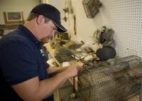 Dale Waites, U.S. Department of Agriculture wildlife biologist, weaves slipknots onto a live trap at Minot Air Force Base, N.D., July 15, 2016. Waites relocates birds away from the airfield, as part of the Bird Airstrike Hazard program (BASH), to mitigate damage to aircraft engines. (U.S. Air Force photo/Airman 1st Class J.T. Armstrong)