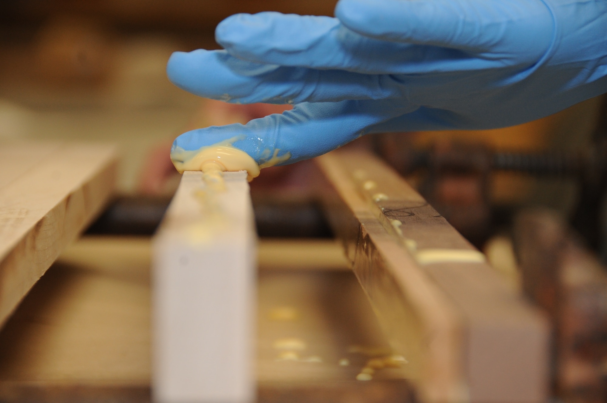Airman 1st Class Justice Fisher, 2nd Munitions Squadron commander support staff, applies glue to a piece of wood to make a cutting board at Barksdale Air Force Base, La., July 18, 2016. The wood must be clamped together and dried overnight. (U.S. Air Force photo/Airman Alexis C. Frost)
