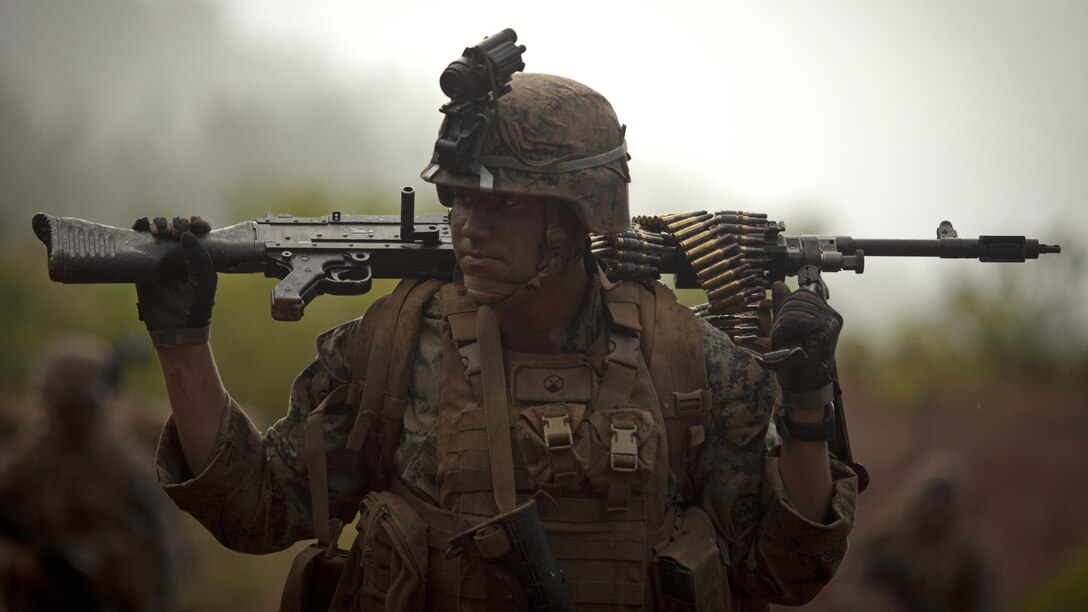 U.S. Marine Cpl. Carson P. Burke, a rifleman with Kilo Company, 3rd Battalion, 4th Marine Regiment, carries an M240G machine gun during the Advanced Infantry Course at Kahuku Training Area, Hawaii, July 18, 2016. AIC is intermediate training designed to enhance and test the Marine's skills and leadership abilities as squad leaders in a rifle platoon.