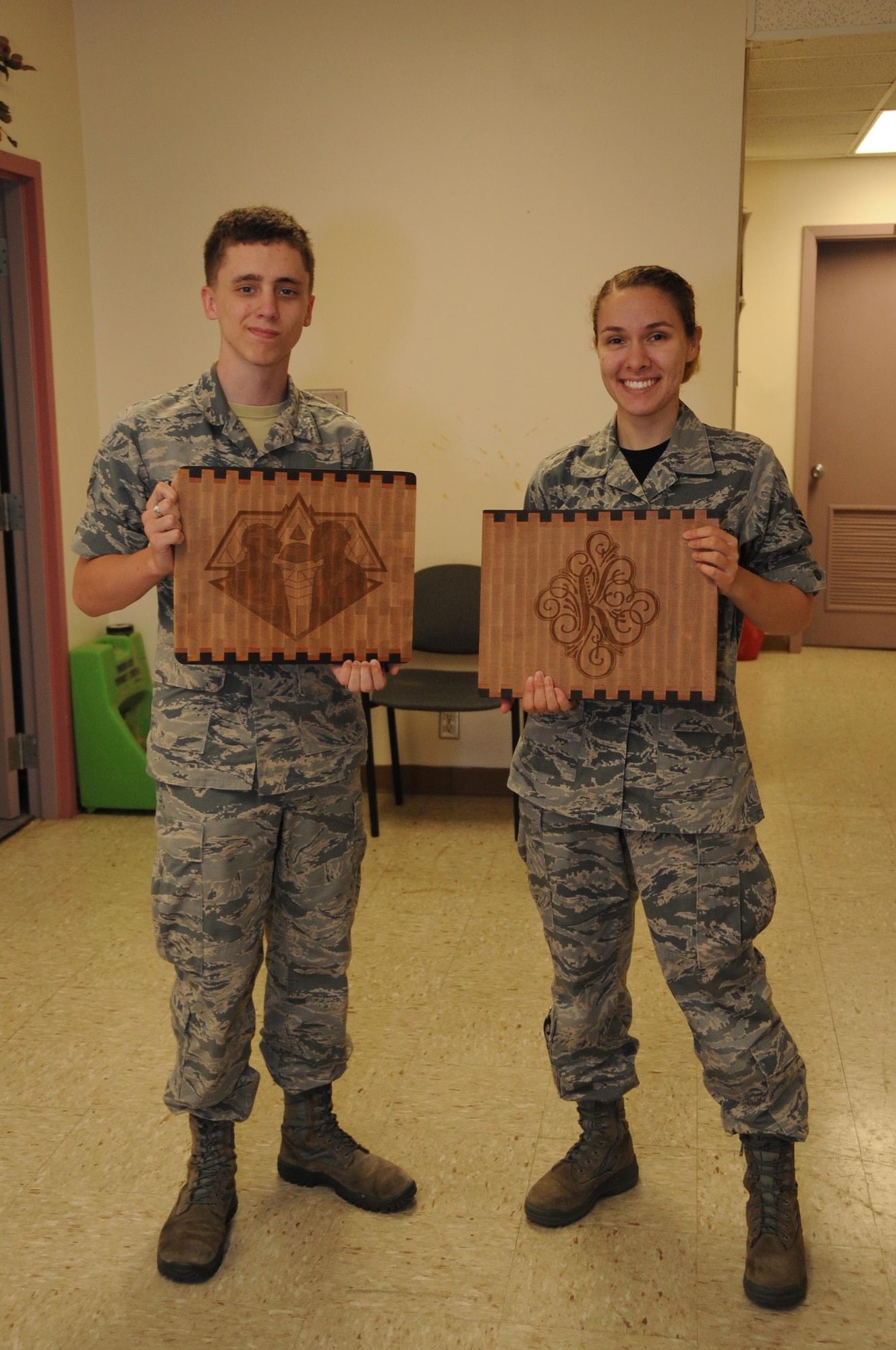 Senior Airman Natalie Kennon and Airman 1st Class Justice Fisher, 2nd Munitions Squadron commander support staff, 
hold up their finished cutting boards at the wood shop at Barksdale Air Force Base, La., July 22, 2016. The Wood Shop offers professional instruction on all aspects of woodworking for wood hobbyists, from the beginner to the most seasoned carpenters. (U.S. Air Force photo/Airman Alexis C. Frost)