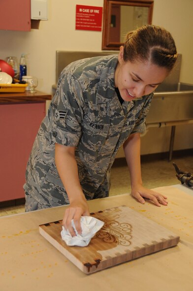 Senior Airman Natalie Kennon, 2nd Munitions Squadron commander support staff, oils her finished cutting board at the wood shop at Barksdale Air Force Base, La., July 22, 2016. Mineral oil was used to bring out the colors in the cutting board. (U.S. Air Force photo/Airman Alexis C. Frost)