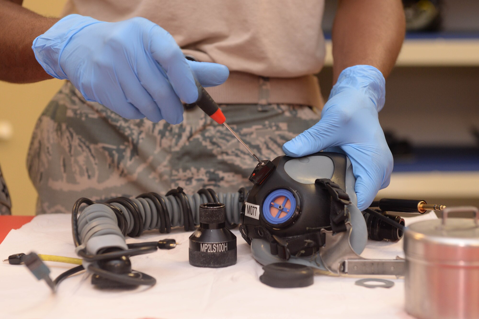 An Airman from the 5th Operations Support Squadron aircrew flight equipment section tightens screws to re-install the helmet’s microphone at Minot Air Force Base, N.D., July 26, 2016. Cleaning and inspecting helmets ensures proper function for pilots. (U.S. Air Force photo/Airman 1st Class Jessica Weissman)