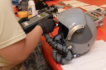 An Airman from the 5th Operations Support Squadron aircrew flight equipment section tests a helmet’s microphone at Minot Air Force Base, N.D., July 26, 2016. The microphones are tested to ensure pilots can hear the correct frequencies and the device works properly. (U.S. Air Force photo/Airman 1st Class Jessica Weissman)