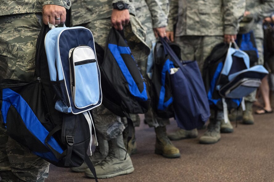 U.S. Air Force Airmen hold backpacks during the Back to School Brigade, July 27, 2016, at Moody Air Force Base, Ga. There will be another back to school event Aug. 17, at the Airman and Family Readiness Center. (U.S. Air Force photo by Airman 1st Class Janiqua P. Robinson)