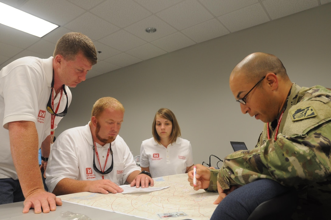 Members of a temporary emergency power planning and response team chart locations of life-saving facilities during a regional power mission exercise conducted July 20 at the FEMA Distribution Center in Atlanta, Georgia.