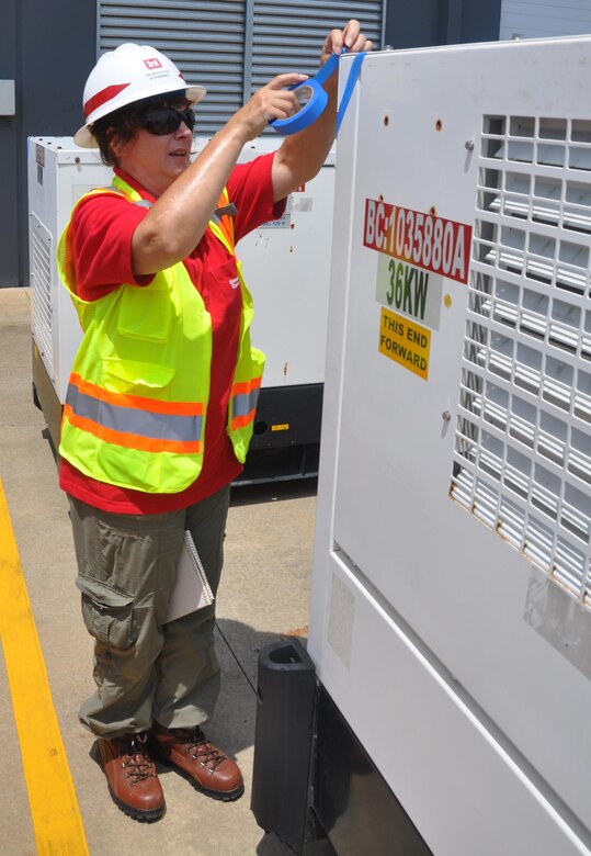Quality Assurance Specialist Beverly Dietz uses blue tape to flag generators ready for pre-installation inspections. Dietz was part of a temporary emergency power team who participated in a regional power mission exercise at the Federal Emergency Management Agency Distribution Center in Atlanta, Georgia July 20. 