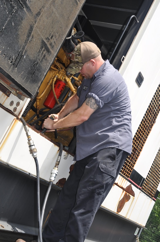 A member of the Federal Emergency Management Agency's Emergency Support Function simulates installation of a generator during a regional power mission exercise conducted July 20 at the FEMA Distribution Center in Atlanta, Georgia.