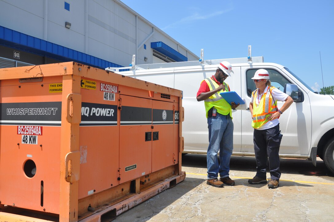 Nanson Petit-Homme, a logistics coordinator, and Nancy Church, a logistic subject matter expert, track generators in a staging area established for a regional power mission exercise conducted July 20 at the Federal Emergency Management Agency Distribution Center in Atlanta, Georgia. 