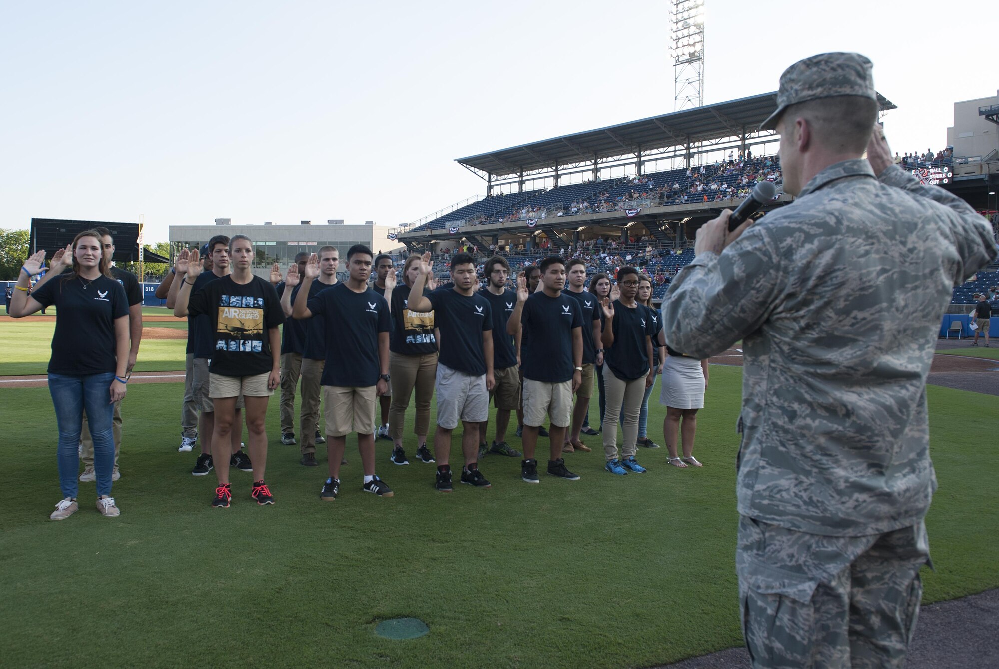 U.S. Air Force Col. Jason Brown, 480th Intelligence, Surveillance and Reconnaissance Wing commander, issues the oath of enlistment to Air Force Delayed Entry Program participants at the Norfolk Tides Air Force Appreciation Night baseball game in Norfolk, Va., July 23, 2016. The event included a presentation of colors by the Langley Air Force Base honor guard and music by the Air Combat Command Heritage of America Band. (U.S. Air Force photo by Airman 1st Class Kaylee Dubois)