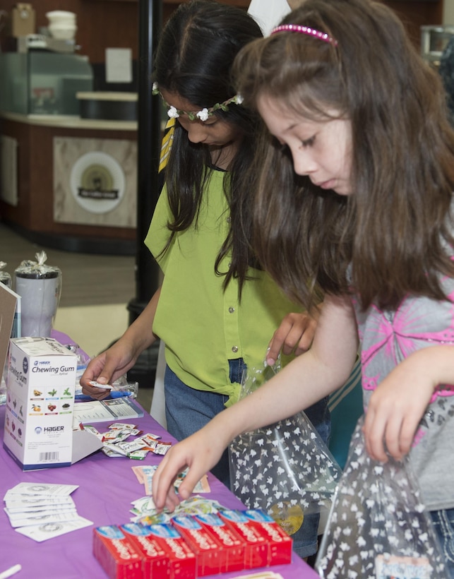 Vishayla and Elrie Beauchan, ages 10 and 8 respectively, daughters of Tech Sgt. Bradley Beauchan, 45 Intelligence Squadron full-motion video imagery analysist, fill gift bags with dental hygiene products at the physical day hosted at U.S. Air Force Hospital Langley at Langley Air Force Base, Va., July 20, 2016. The physical day is the first of two days, with the next scheduled for Aug. 10.  (U.S. Air Force photo by Airman 1st Class Kaylee Dubois)
