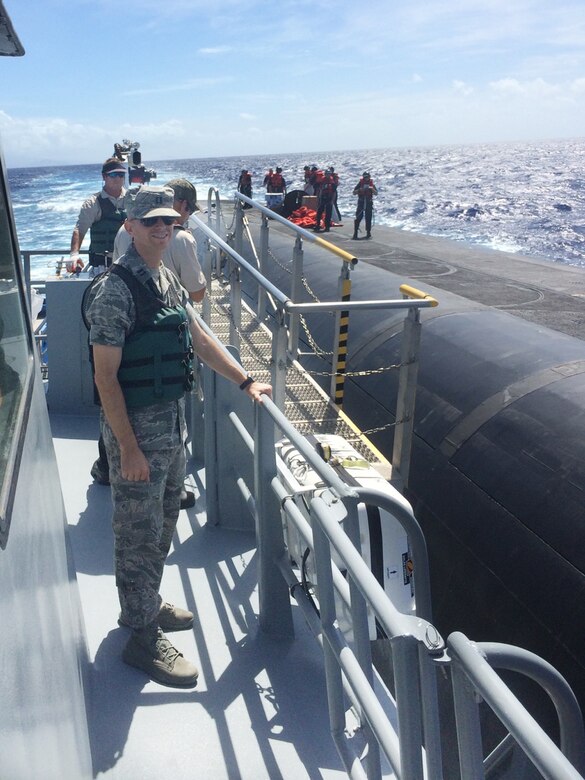 Air Force Capt. Cody daMota poses for a photo aboard the Personnel Transfer Vessel Malama during an open-ocean personnel transfer with a ballistic missile submarine, Aug. 15, 2015. DaMota is one of the first four Air Force intercontinental ballistic missile officers selected to serve with U.S. Navy Submarine Forces ballistic missile submarine units through the Striker Trident nuclear officer exchange program. In May, he left the 91st Missile Wing at Minot Air Force Base, N.D., to begin a three-year assignment as an assistant nuclear weapons surety officer in the strategic forces, nuclear weapons and force protection directorate at Commander, Submarine Force, U.S. Pacific Fleet, Joint Base Pearl Harbor-Hickam, Hawaii. The Striker Trident exchange program enables Navy and Air Force nuclear-qualified officers to gain an expanded view of the nuclear triad, as well as each leg’s respective role in U.S. Strategic Command’s strategic deterrence mission. Air Force photo by Capt. Patrick McAfee