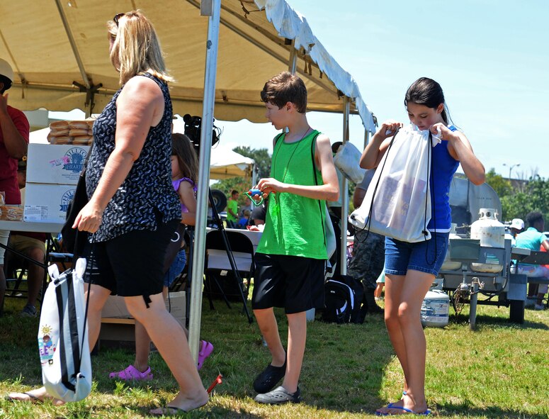 A Team Shaw member looks inside a backpack during the Exceptional Family Member Program Kid’s Jamboree at Shaw Air Force Base, S.C., July 27, 2016. Team Shaw children were treated to various school items, and free food and drinks throughout the event. (U.S. Air Force photo by Airman 1st Class Christopher Maldonado)