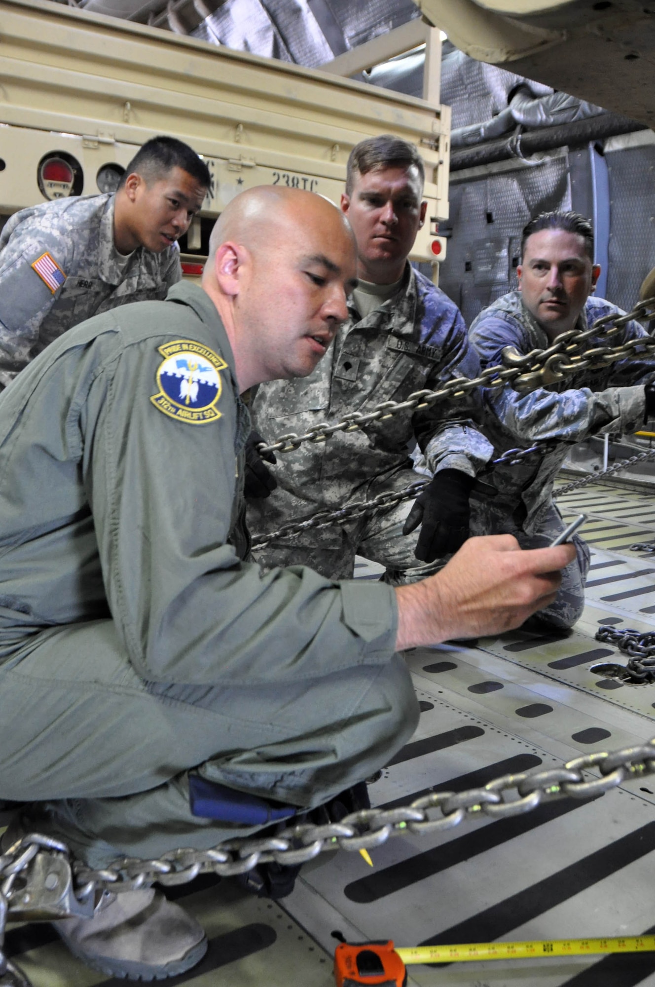 Tech. Sgt. Daniel Carroll, a loadmaster with the 312th Airlift Squadron instructs Soldiers part of the 238th Transportation Company from the Military Ocean Terminal in Concord, Calif., how to calculate the appropriate number of restraints necessary to secure a tactical vehicle on a C-5 Galaxy cargo aircraft at Travis Air Force Base, Calif., July 23, 2016.  The PATRIOT WYVERN exercises are hands-on, bi-annual events conducted by the 349th Air Mobility Wing designed to hone combat skills and improve organizational interoperability. The code name "Patriot" is common to many Air Force Reserve led exercises, such as Operation PATRIOT EXPRESS. The wyvern name derives from the mythical winged creature found on the 349th AMW's unit crest. (U.S. Air Force photo by Staff Sgt. Cindy G. Alejandrez)