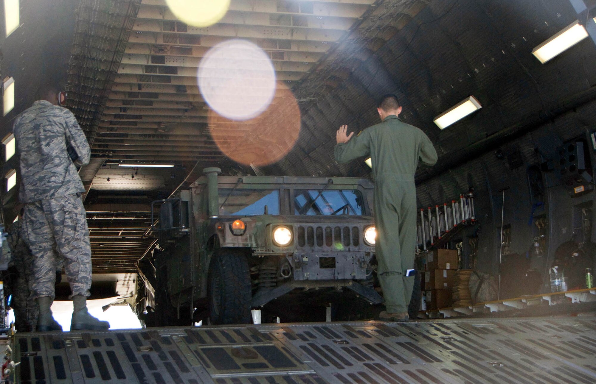 Senior Airman Kyle Alcantara, a loadmaster with the 312th Airlift Squadron guides a tactical vehicle driven by a member of the 238th Transportation Company from the Military Ocean Terminal in Concord, Calif., off of a C-5 Galaxy cargo aircraft, during exercise PATRIOT WYVERN, July 23, 2016. The PATRIOT WYVERN exercises are hands-on, bi-annual events conducted by the 349th Air Mobility Wing designed to hone combat skills and improve organizational interoperability. The code name "Patriot" is common to many Air Force Reserve led exercises, such as Operation PATRIOT EXPRESS. The wyvern name derives from the mythical winged creature found on the 349th AMW's unit crest. (U.S. Air Force photo by Staff Sgt. Cindy G. Alejandrez)