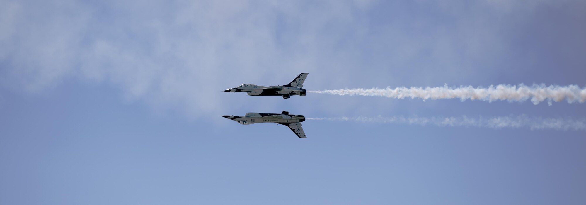 Maj. Alex Turner, Thunderbirds #6 opposing solo pilot, and Capt. Nicholas Eberling, Thunderbirds #5 lead solo pilot, perform a reflection pass during Cheyenne Frontier Days, July 27, 2016, in Cheyenne, Wyo. The Thunderbirds performed twists, turns and rolls at high speeds demonstrating the prowess and capabilities of the F-16 Fighting Falcon aircraft. (U.S. Air Force photo by Senior Airman Brandon Valle)