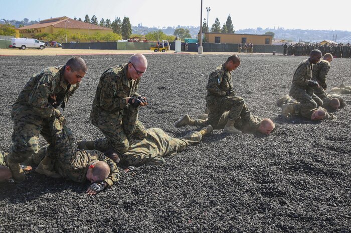 Recruits from Mike Company, 3rd Recruit Training Battalion, conduct unarmed takedowns during a Marine Corps Martial Arts Program test at Marine Corps Recruit Depot San Diego, July 20. Twenty recruits at a time took the test as the instructors evaluated them on hand-to-hand combat techniques and various movements with simulated knives and rifles. Annually, more than 17,000 males recruited from the Western Recruiting Region are trained at MCRD San Diego. Mike Company is scheduled to graduate Aug. 12.