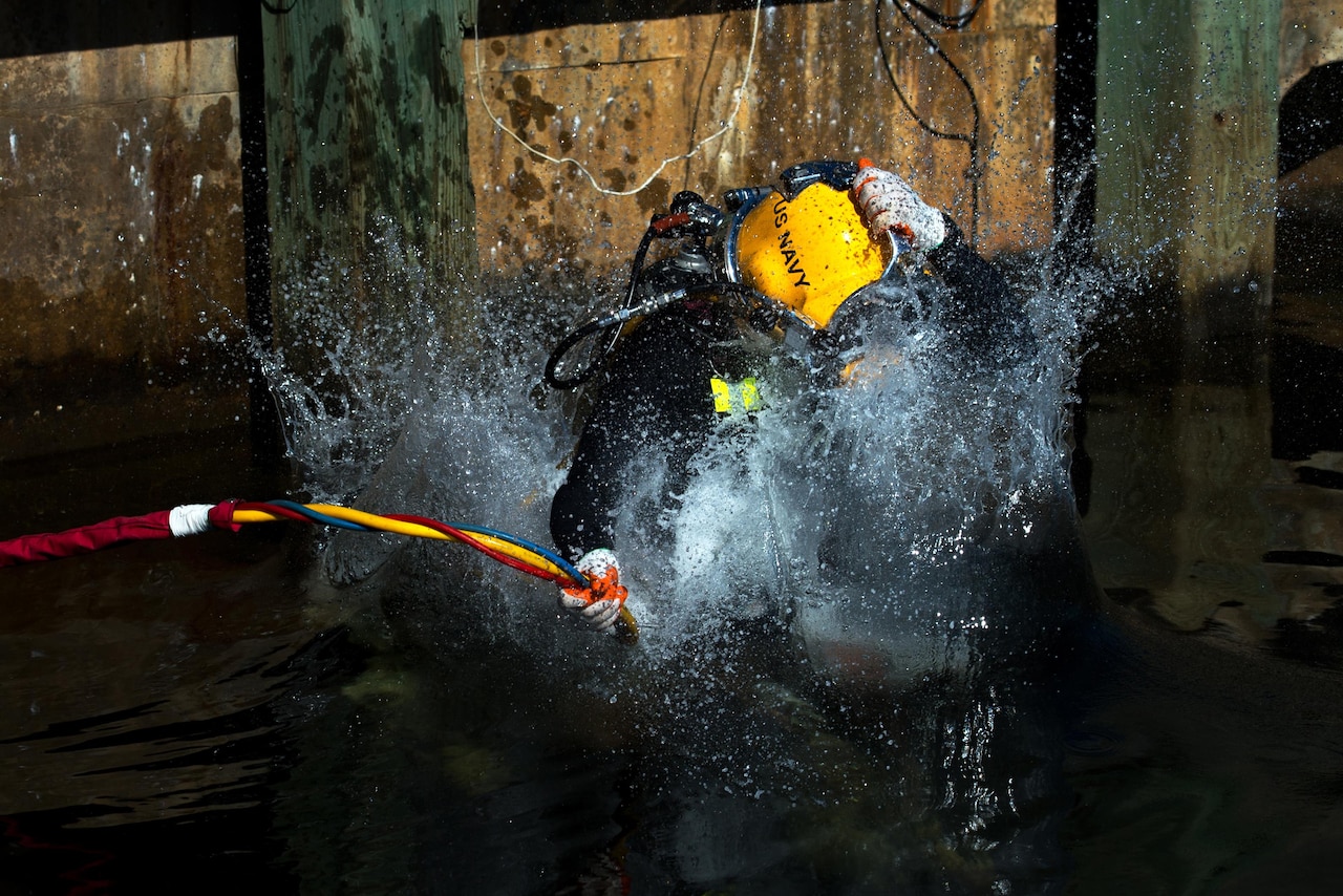 Navy diver Petty Officer 1st Class Jason Fenn enters the water for training in murky water at the Naval Support Activity Panama City in Panama City, Fla., July 14, 2016. Fenn is assigned to the Naval Surface Warfare Center Panama City Division dive locker. DoD photo by EJ Hersom