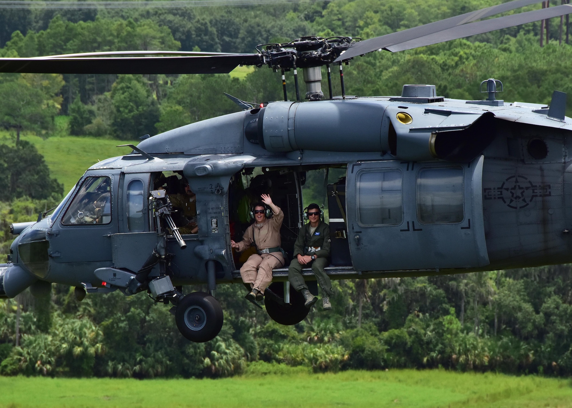 Staff Sgt. Alexandra Rambaran, 924th Operations Support Flight intelligence analyst, and 1st Lt.  Stephen Crump, 47th Fighter Squadron student pilot, sit off the side of a HH-60G Pave Hawk helicopter July 21 enroute to Patrick Air Force Base, Fla. The two were part of a training exercise focused on tactics the A-10C can offer during combat operations, providing close air support for the combat search and rescue squadron. Approximately 200 Airmen from the 924th conducted their annual tour at Patrick Air Force Base, allowing the unit from Arizona to gain experience and train with the 920th Rescue Wing.   (U.S. Air Force photo by Tech. Sgt. Louis Vega Jr.)