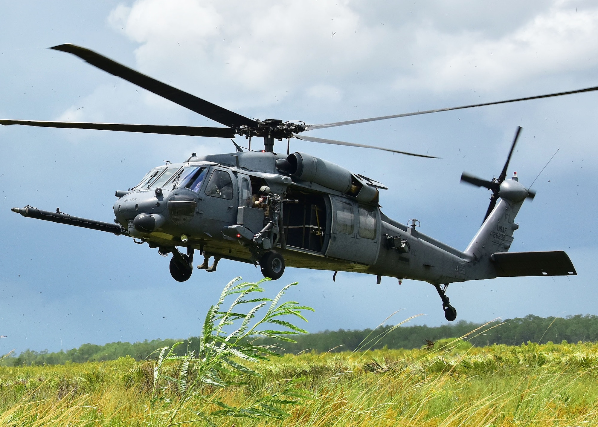 An HH-60G Pave Hawk helicopter from the 301st Rescue Squadron prepares to land for simulated stranded survivors during training with A-10C Thunderbolt II aircraft from the 924th Fighter Group July 20 at Avon Park Air Force Range, Fla. The training focused on tactics the A-10C can offer during combat operations, providing close air support for the combat search and rescue squadron. Approximately 200 Airmen from the 924th conducted their annual tour at Patrick Air Force Base, allowing the unit from Arizona to gain experience and train with the 920th Rescue Wing.  (U.S. Air Force photo by Tech. Sgt. Louis Vega Jr.)
