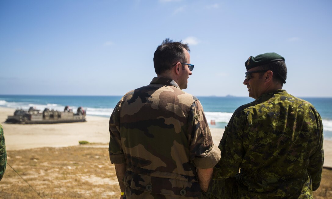 Canadian Army Col. M.H. St-Louis, Commander of 5 Canadian Mechanized Brigade Group, speaks to French Navy Lt. Cmdr. Numa Durbec, head of international affairs office in the joint HQ, New Caledonia, during an amphibious landing demonstration at the USPACOM Amphibious Leaders Symposium (PALS) on Camp Pendleton, Calif., July 13, 2016. PALS brings together senior leaders of allied and partner nations from the Indo-Asia-Pacific region to discuss key aspects of maritime/amphibious operations, capability development, crisis response, and interoperability. Twenty-two allied and partnered nations, including the U.S. are participating. 
