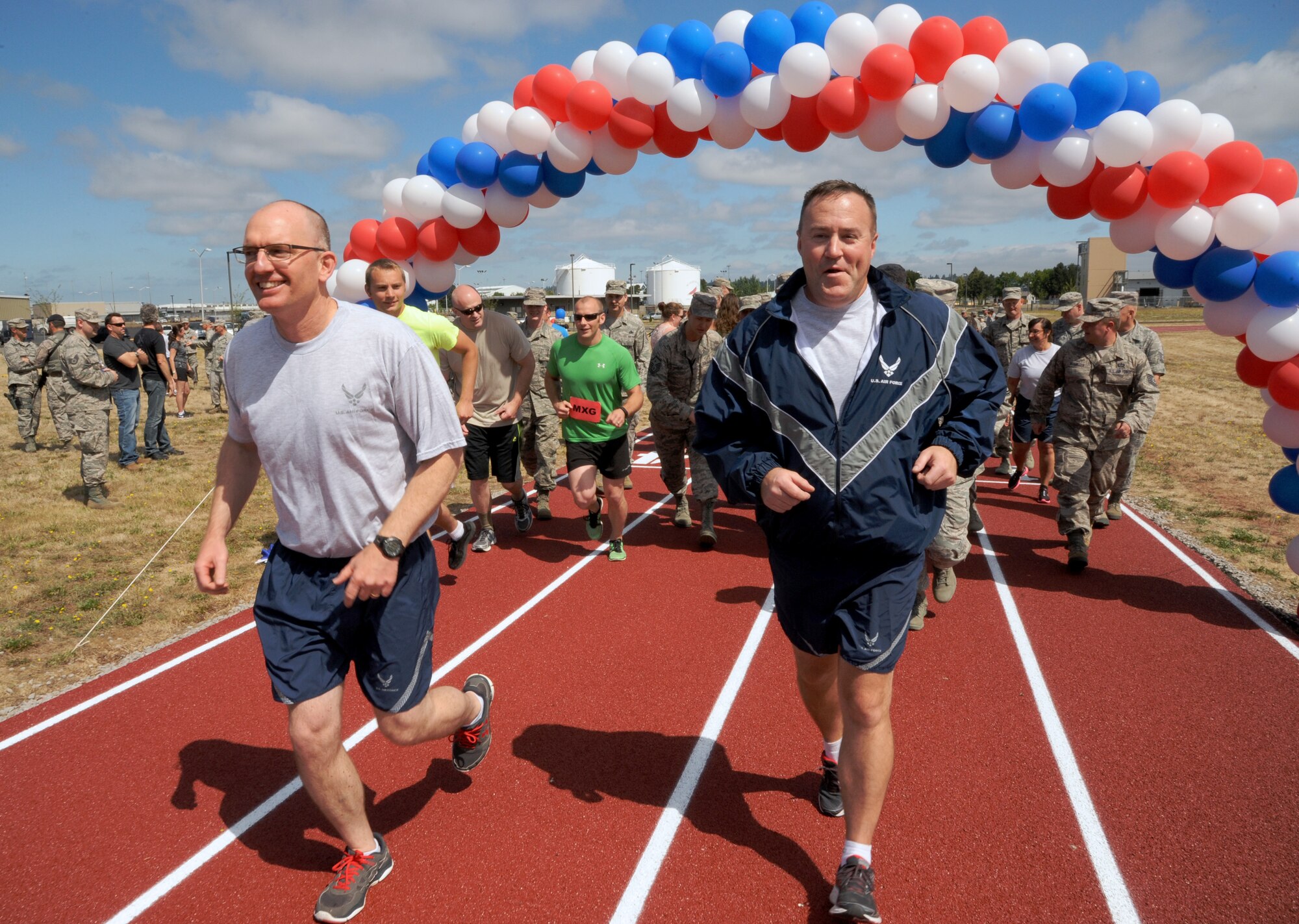 Oregon Air National Guard Col. Paul Fitzgerald, 142nd Fighter Wing commander, left, and Chief Master Sgt. Chris Roper, 142nd Fighter Wing command chief, right, lead a group of Airmen and base staff during a ceremonial first lap as part of the official opening of the new base track, Portland Air National Guard Base, Ore., July 26, 2016. (U.S. Air National Guard photo by Tech. Sgt. John Hughel, 142nd Fighter Wing Public Affairs/Released)