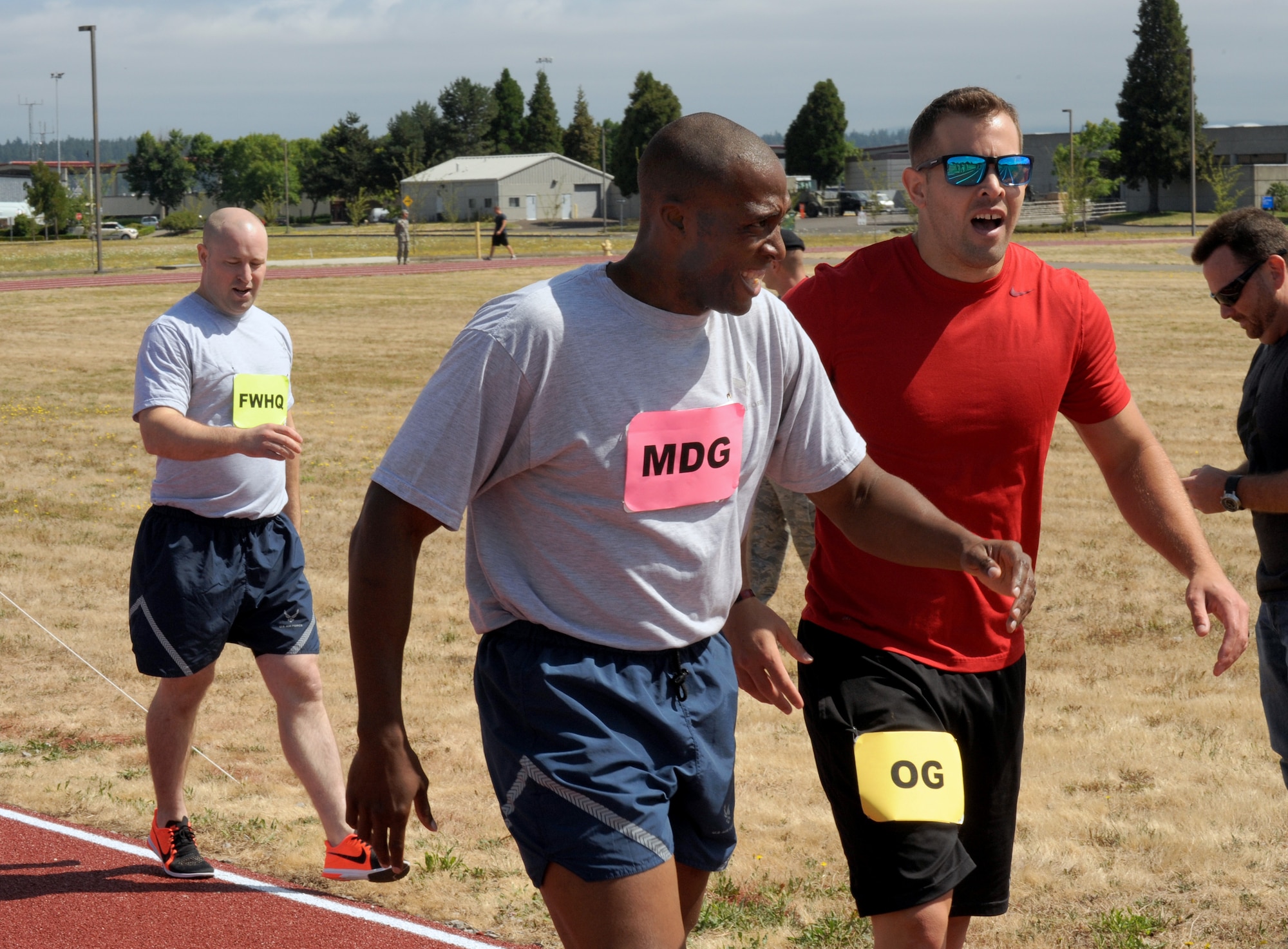 Oregon Air National Guard Tech. Sgt. Justin Comfort, right, and Staff Sgt. Breland Reed,  center, along with Staff Sgt. Andrew Hensley, left, attempt to catch their breath after their quarter mile race held at the new track at the Portland Air National Guard Base, Ore., July 26, 2016. (U.S. Air National Guard photo by Tech. Sgt. John Hughel, 142nd Fighter Wing Public Affairs/Released)