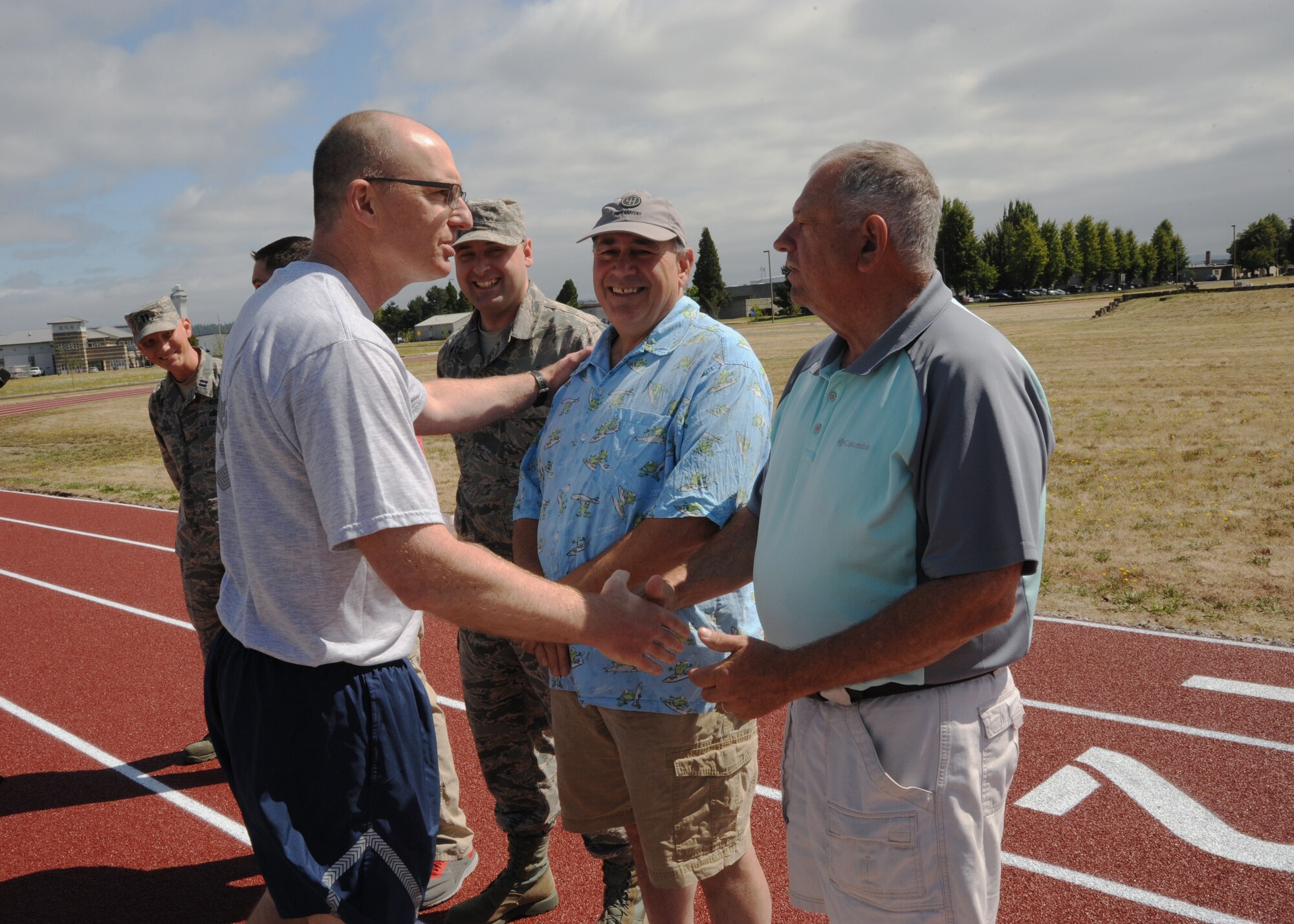 Oregon Air National Guard Col. Paul Fitzgerald, 142nd Fighter Wing commander, left, thanks Mike Godsey, right, during the official opening of the new base track as he acknowledges members from the 142nd Fighter Wing Civil Engineer Squadron who helped build the newest on base construction project, July 26, 2016, Portland Air National Guard Base, Ore. (U.S. Air National Guard photo by Tech. Sgt. John Hughel, 142nd Fighter Wing Public Affairs/Released)