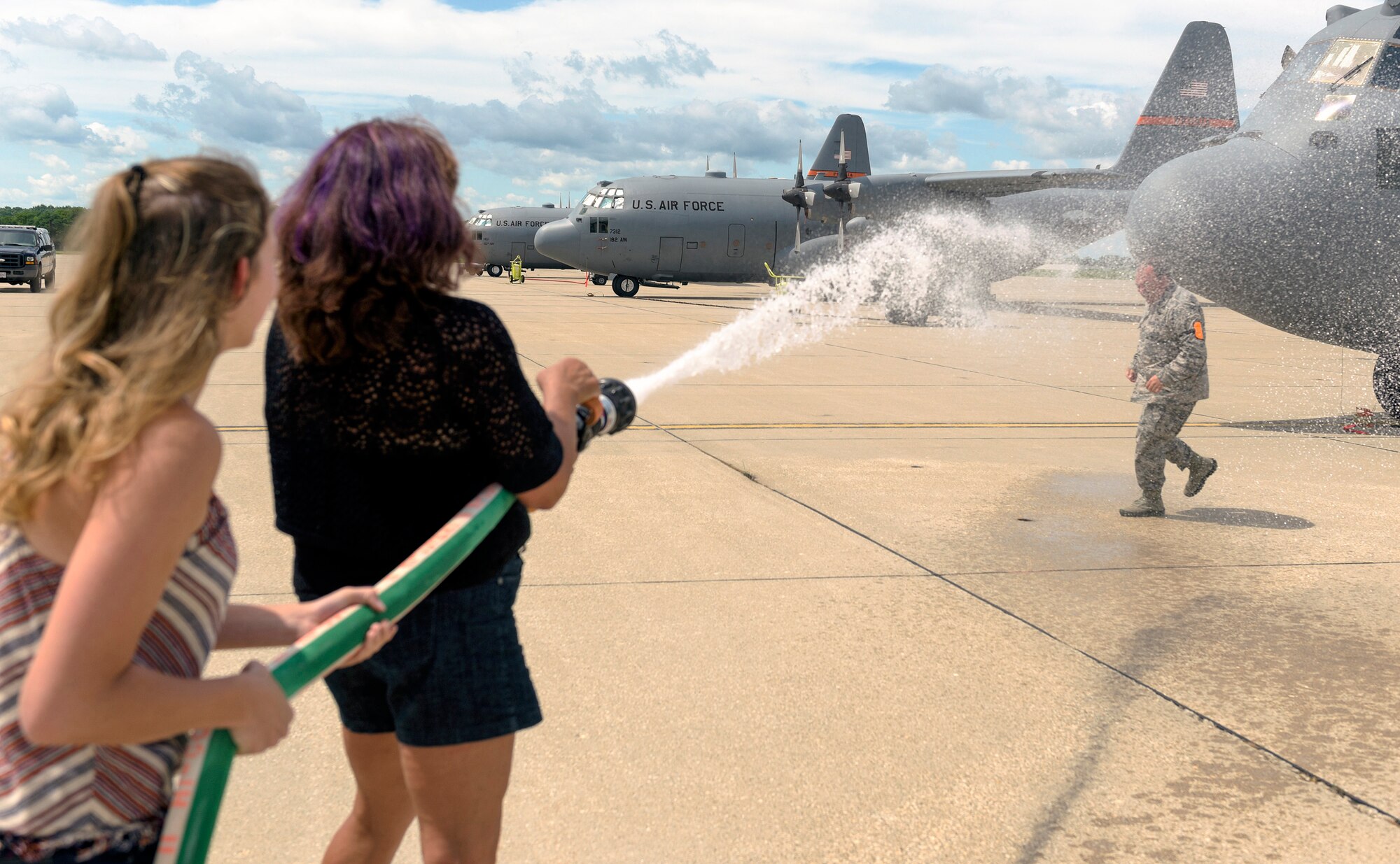 U.S. Air Force Col. Barton Welker, the commander of the 182nd Maintenance Group, Illinois Air National Guard, is doused with water by his spouse after his “fini flight” at the 182nd Airlift Wing in Peoria, Ill., July 25, 2016. Welker is scheduled to retire Aug. 1 after 34 years of military service. (U.S. Air National Guard photo by Staff Sgt. Lealan Buehrer)