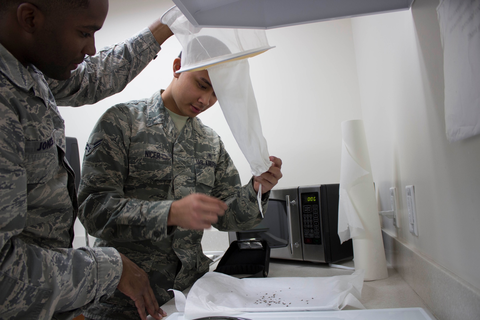 Staff Sgt. Derrick Jones and Airman 1st Class Stephen Nicer get ready to examine the contents of a mosquito trap at Eglin Air Force Base, Florida. (U.S. Air Force Photo/Susan Lawson)
