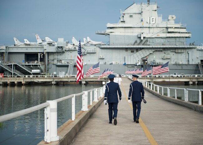 Airmen walk towards the USS Yorktown before the Naval Support Activity Charleston change of command, July 21, 2016, Charleston, S.C. U.S. Navy Capt. Robert Hudson took command of NSA Charleston from his predecessor Capt. Timothy Sparks. Hudson previously served as the Nuclear Power Training Unit Charleston commander. Sparks is retiring after 38 years of military service. (U.S. Air Force photo/Staff Sgt. Jared Trimarchi) 