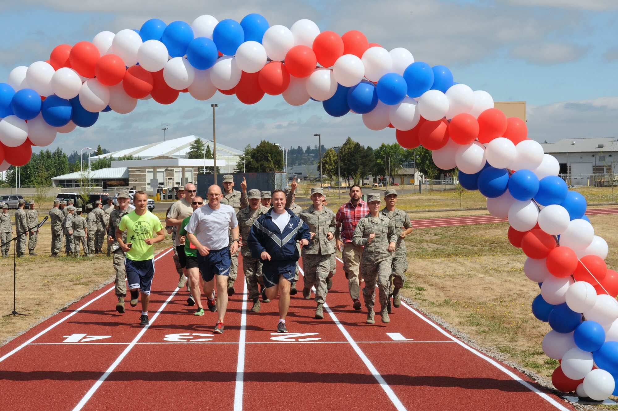 Oregon Air National Guard Col. Paul Fitzgerald, 142nd Fighter Wing commander, left, and Chief Master Sgt. Chris Roper, 142nd Fighter Wing command chief, right,and other base staff complete a ceremonial first lap as part of the official opening of the new base track, Portland Air National Guard Base, Ore., July 26, 2016. (U.S. Air National Guard photo by Tech. Sgt. John Hughel, 142nd Fighter Wing Public Affairs/Released)