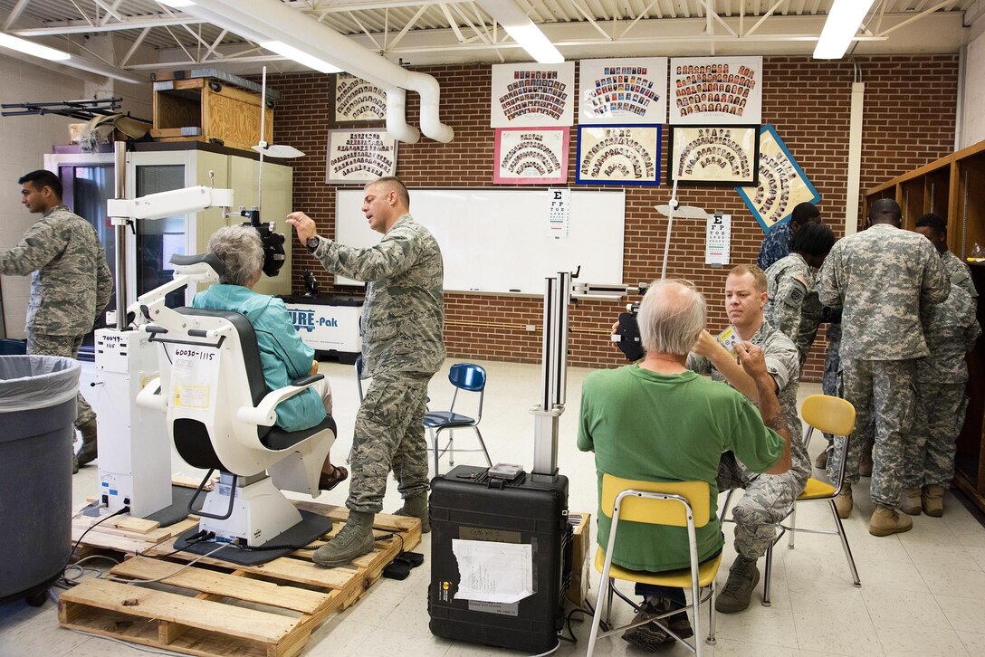 Service members examine patients during the Greater Chenango Cares Innovative Readiness Training in Cortland, N.Y., July 18, 2016. The exercise provided medical care, veterinary services, dental care, optometry exams and glasses on-site to patients at no cost. Air National Guard photo by Senior Master Sgt. Elizabeth Gilbert