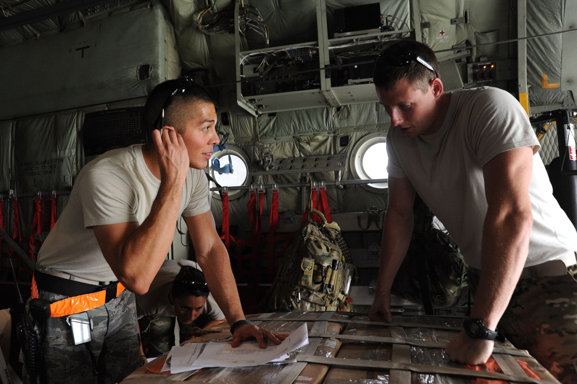 Staff Sgt. Oscar Sorto, left, 386th Expeditionary Logistics Readiness Squadron air terminal operations center ramp controller, discusses the load with Staff Sgt. Drew Schubauer, 746th Expeditionary Airlift Squadron loadmaster, July 21, 2016 at an undisclosed location in Southwest Asia. The ATOC is the nerve center of operations for the 386 ELRS aerial port and provides the rest of the team with updates on mission status. (U.S. Air Force photo/Senior Airman Zachary Kee)