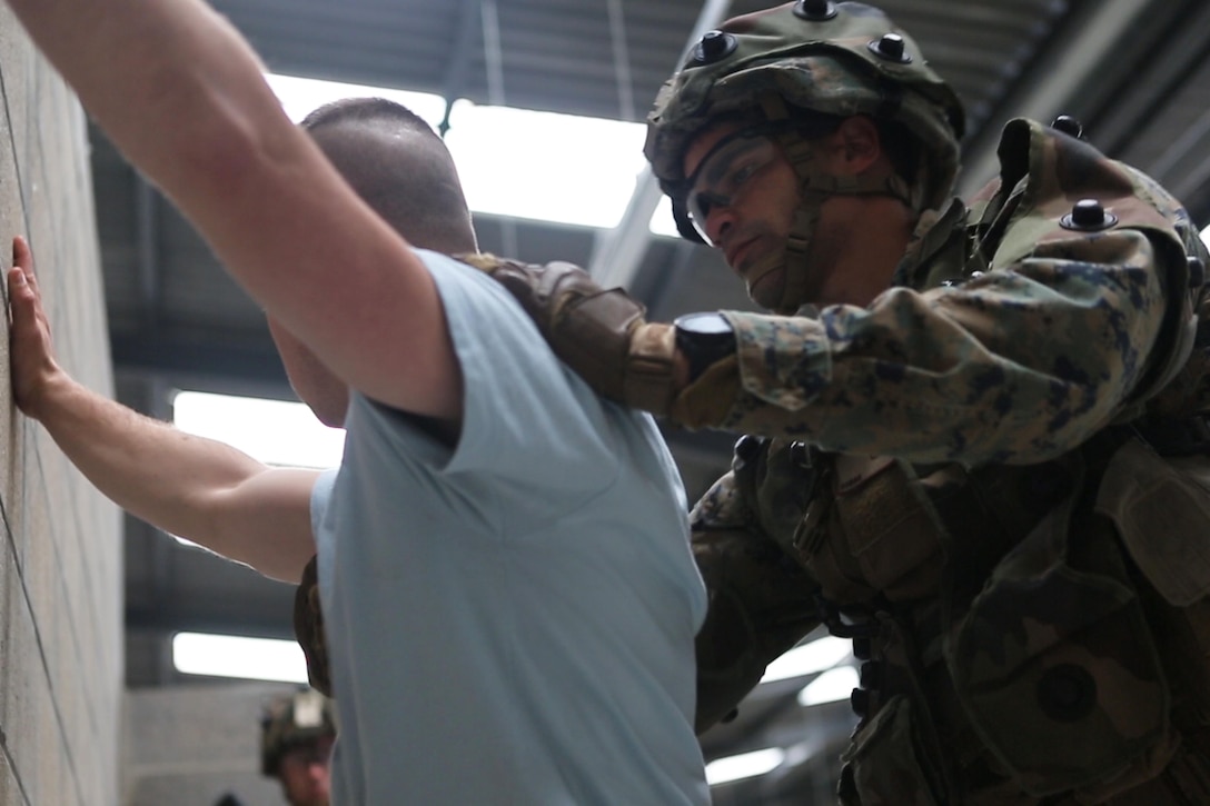 U.S. Marine Corps Lance Cpl. Guillermo J. Avilesperez, a rifleman with Bravo company, 1st Battalion, 8th Marine Regiment, Special Purpose Marine Air-Ground Task Force-Crisis Response-Africa searches a simulated civilian for weapons during a Non-combatant evacuation operation exercise hosted by French Army Center for Urban Combat Training instructors aboard Camp Sissonne, France, June 21, 2016. SPMAGTF-CR-AF Marines trained alongside a company of French Army soldiers, integrating their skills and resources to form an effective battle plan, similar to what they may face in the event of a future crisis. (U.S. Marine Corps photo by Sgt. Kassie L. McDole/Released) 