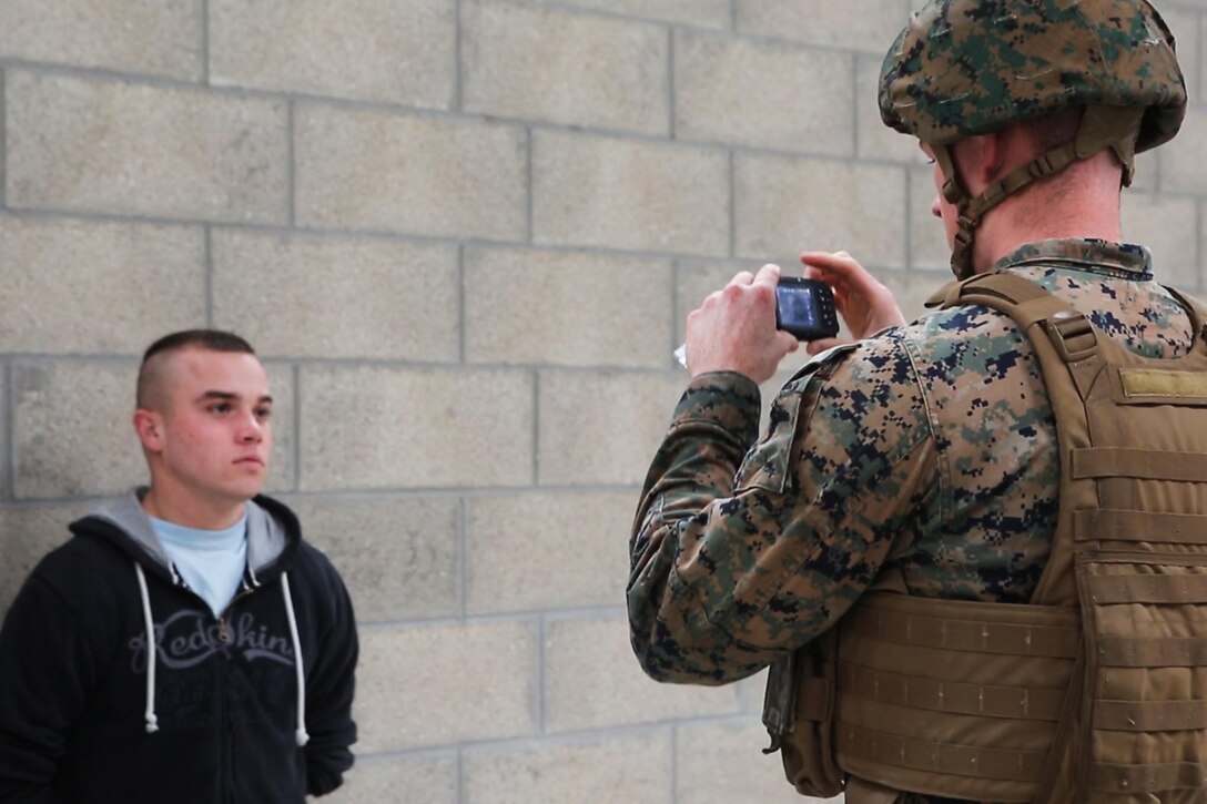 U.S. Marine Corps Sgt. Taylor R. Lefevre, with Special Purpose Marine Air-Ground Task Force-Crisis Response-Africa captures a photo of a simulated civilian for future identification during a Non-combatant evacuation operation exercise hosted by French Army Center for Urban Combat Training instructors aboard Camp Sissonne, France, June 21, 2016. SPMAGTF-CR-AF Marines trained alongside a company of French Army soldiers, integrating their skills and resources to form an effective battle plan, similar to what they may face in the event of a future crisis. (U.S. Marine Corps photo by Sgt. Kassie L. McDole/Released) 