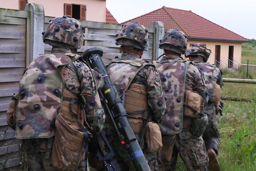 U.S. Marines with Bravo company, 1st Battalion, 8th Marine Regiment, Special Purpose Marine Air-Ground Task Force-Crisis Response-Africa prepare to engage simulated enemy during a Non-combatant evacuation operation exercise hosted by French Army Center for Urban Combat Training instructors aboard Camp Sissonne, France, June 21, 2016. SPMAGTF-CR-AF Marines trained alongside a company of French Army soldiers, integrating their skills and resources to form an effective battle plan, similar to what they may face in the event of a future crisis. (U.S. Marine Corps photo by Sgt. Kassie L. McDole/Released)