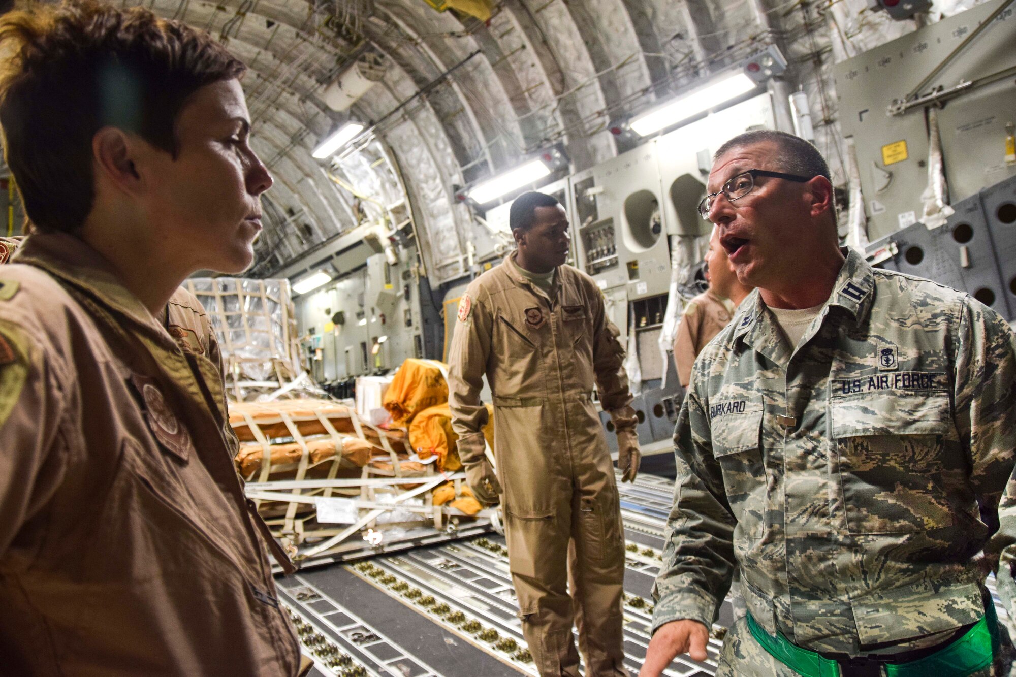 Capt. Mark Burkard, 379th Enroute Patient Staging Facility registered nurse, talks with a member of the aeromedical evacuation team about the patients loaded onto a C-17 Globemaster III July 18, 2016, at Al Udeid Air Base, Qatar.  The patients were enroute to Landstuhl Regional Medical Center Germany for a higher level of care. (U.S. Air Force photo/Technical Sgt. Carlos J. Treviño)